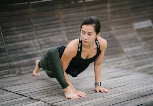 ragazza fa stretching su pedana di legno
