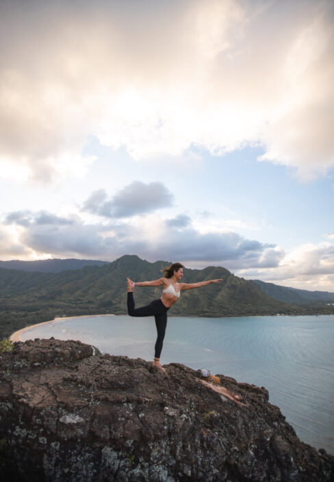 ragazza fa yoga con panorama di montagne e mare